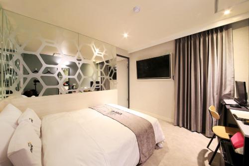 a hotel room with a bed and a television at DUNE45 in Suwon