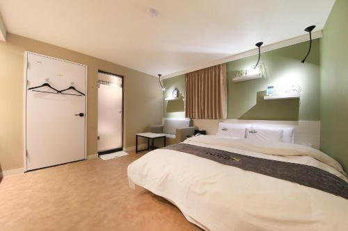 a bedroom with a large bed and a door at DUNE45 in Suwon