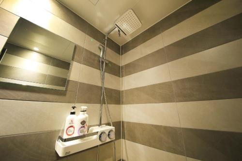 a bathroom with a shower with two bottles on a shelf at DUNE45 in Suwon