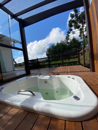 a bath tub sitting on top of a wooden deck at Chalé Uirapurus in Monte Verde