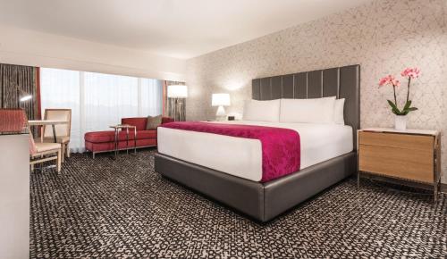 a hotel room with a bed and a dresser at Flamingo Las Vegas Hotel & Casino in Las Vegas