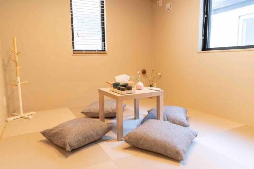 a room with a table and two ottomans at 新宿中心高級稀有新建別墅，JR線新大久保徒步4分鐘露台免費Wi-Fi in Tokyo