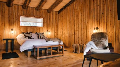 um quarto com uma cama com um cão deitado sobre ela em Patagonia East River em Llanada Grande