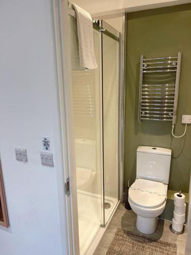 a bathroom with a shower and a toilet with a glass door at Cambridge Studios and Suites by Tas Accommodations in Cambridge