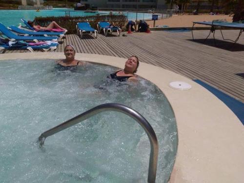 two people in a hot tub in a swimming pool at DEPARTAMENTO HERMOSO CON VISTA AL MAR in Algarrobo