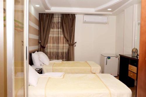 pokój hotelowy z 2 łóżkami i oknem w obiekcie Salvatore Room With Breakfast-Behind Asyut Train Station w mieście Asjut