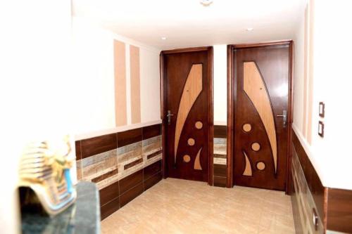 Habitación con 2 puertas de madera en una habitación en Salvatore Room With Breakfast-Behind Asyut Train Station en Asiut