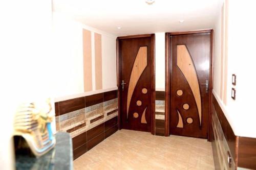 a room with two wooden doors in a room at Salvatore Room With Breakfast-Behind Asyut Train Station in Asyut