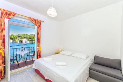 1 dormitorio con 1 cama y balcón con mesa en Apartments by the sea Okuklje, Mljet - 4912, en Maranovići