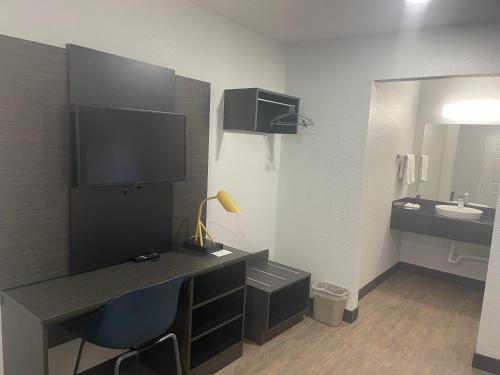 La salle de bains est pourvue d'un bureau avec un lavabo et un miroir. dans l'établissement Motel 6 Denton, TX - UNT, à Denton