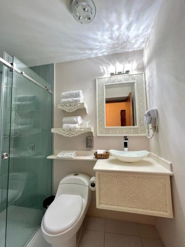 a bathroom with a toilet and a sink and a shower at Dakani Hotel Boutique NEW in Quito