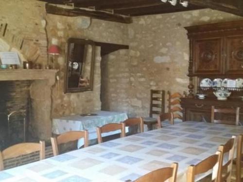 una sala da pranzo con tavolo, sedie e camino di Maison du XVe restaurée avec cheminée, jardin clos et bar privé - FR-1-410-127 a Crannes-en-Champagne
