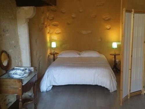 una camera da letto con un letto bianco e due lampade di Maison du XVe restaurée avec cheminée, jardin clos et bar privé - FR-1-410-127 a Crannes-en-Champagne