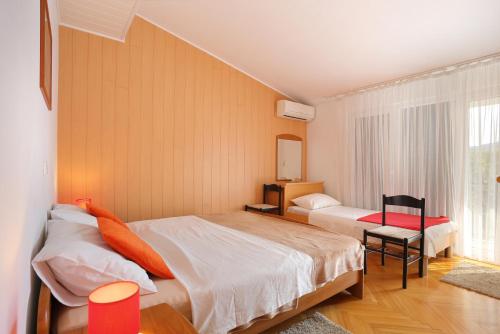 een slaapkamer met 2 bedden en een raam bij Apartments by the sea Poljica, Trogir - 16999 in Marina