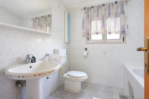 een witte badkamer met een toilet en een wastafel bij Apartments by the sea Poljica, Trogir - 16999 in Marina