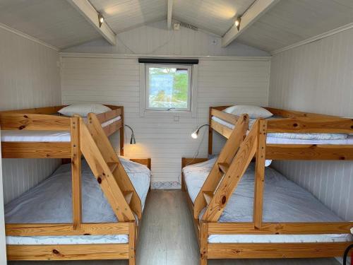 two bunk beds in a small room with a window at Holiday home OSKARSHAM III in Oskarshamn