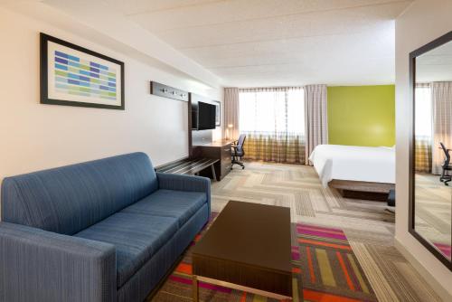 a hotel room with a couch and a bed at Holiday Inn Express Philadelphia NE-Bensalem by IHG in Bensalem