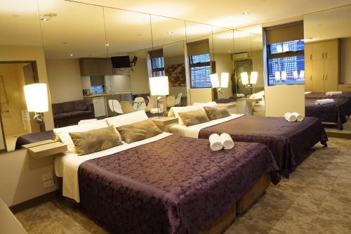 um quarto de hotel com duas camas e um espelho grande em Melbourne ViVo em Melbourne