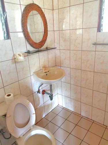 a bathroom with a toilet and a sink at Sulu Sunset Beach Resort in Nauhang