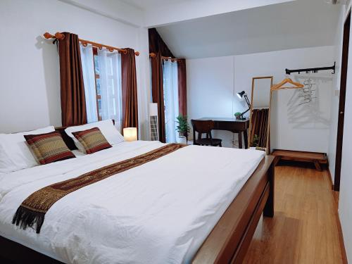 a bedroom with a large bed and a desk at ปรุงสุข in Phra Nakhon Si Ayutthaya