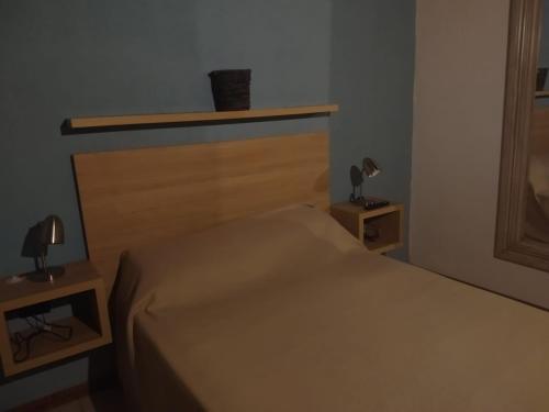 ein Schlafzimmer mit einem Bett und zwei Nachttischen in der Unterkunft Maria in Villa Gesell