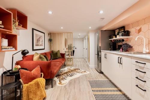 a living room with a red couch and a kitchen at Professionally Designed 1-Bedroom in Prime Toronto in Toronto