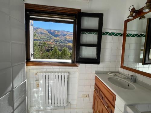 baño con ventana, lavabo y radiador en Mirador del Valle Bed & Breakfast en Eriste