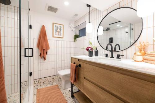 a bathroom with a sink and a mirror and a toilet at Professionally Designed 1-Bedroom in Prime Toronto in Toronto