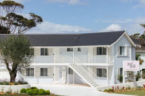 a white house with a black roof at Motel Molly - Boutique Hotel Mollymook in Mollymook