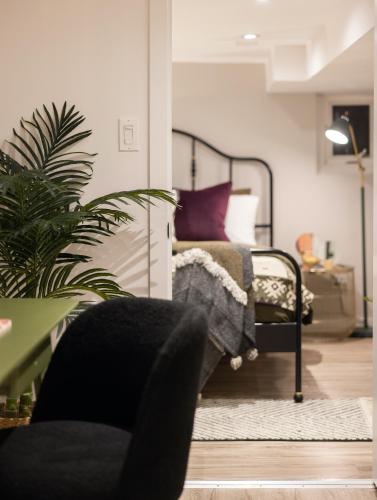 a bedroom with a bed with purple pillows and a plant at Professionally Designed 1-Bedroom in Prime Toronto in Toronto