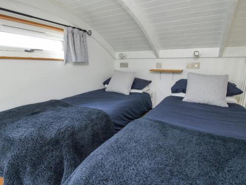 two beds in a small room with a window at Shepherds Cabin at Titterstone in Farden