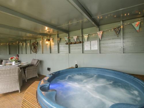 a large blue tub in a room with a table at Shepherds Cabin at Titterstone in Farden