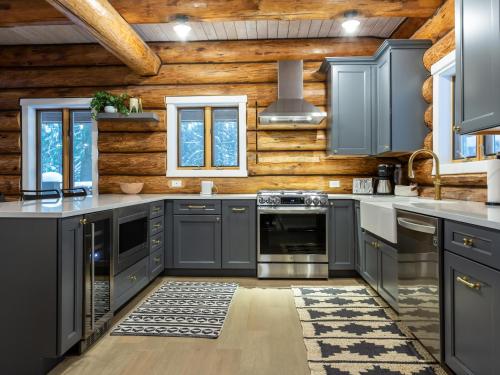 a kitchen with blue cabinets and wooden walls at ArborMyst in Glacier