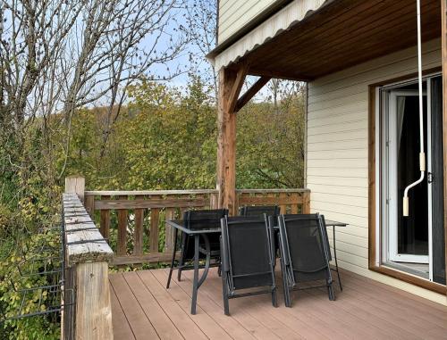 eine Terrasse mit Stühlen und einem Tisch auf einem Haus in der Unterkunft Havre de paix - chambres dhotes in Bellegarde-sur-Valserine