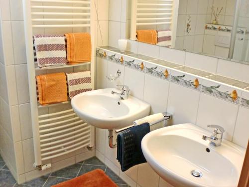 y baño con 2 lavabos, espejo y toallas. en Ferienwohnung Bauernhaus Kailhof en Aschau im Chiemgau