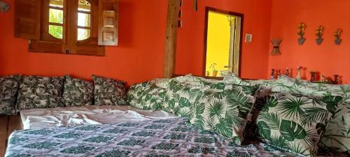 salon z pomarańczowymi ścianami i łóżkiem w obiekcie Villa da Apa w mieście Japaratinga