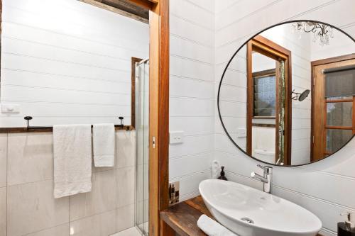 ein Bad mit einem Waschbecken und einem Spiegel in der Unterkunft Sunset Cottage - Yarra Valley in Healesville