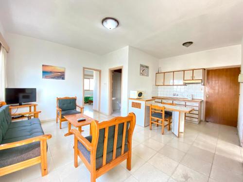 a living room with a couch and a table at Kaan Hotel & Apartment in Kérynia