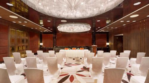 a conference room with white chairs and a chandelier at InterContinental Dhaka by IHG in Dhaka