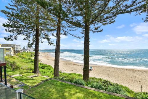 a view of the beach from the balcony of a beach house at Beachside at The Entrance in The Entrance