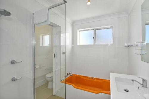 a bathroom with a shower and a sink and a toilet at Beachside at The Entrance in The Entrance