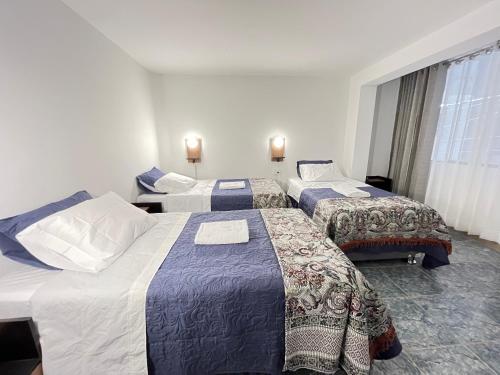 een hotelkamer met 2 bedden en een raam bij Marluc Casa de Descanso in Machu Picchu