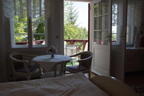 マリアーンスケー・ラーズニェにあるGeorge Pensionのテーブルと椅子、窓が備わる客室です。