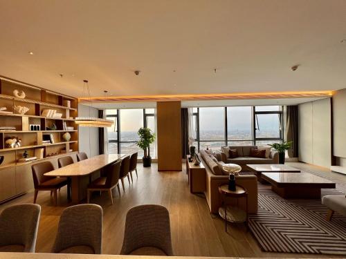 a living room with a couch and tables and chairs at Wanda Jin Xiaohe Xincheng in Taiyuan