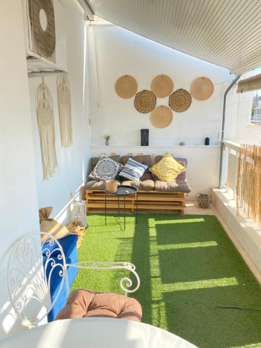 - un salon avec un canapé et un tapis vert dans l'établissement Lycabetus View Loft Downtown Kolonaki, à Athènes