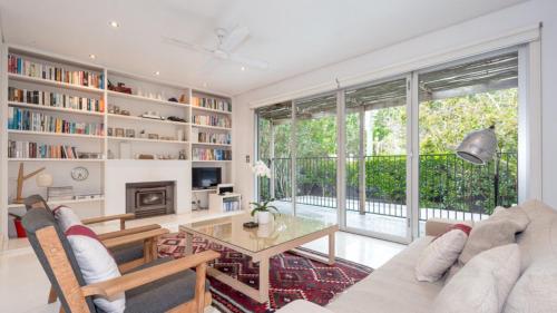 a living room with a couch and a table at Pearl Beach House in Pearl Beach