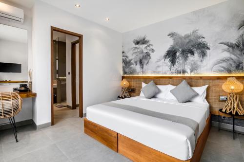 a bedroom with a bed and a painting of palm trees at Villa Jump by BaliSuperHost in Ubud