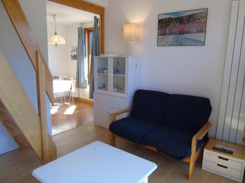 a living room with a blue couch and a table at Charmant T2 avec mezzanine et balcon - 4 pers, parking, proche navettes, Châtel - FR-1-198-122 in Châtel