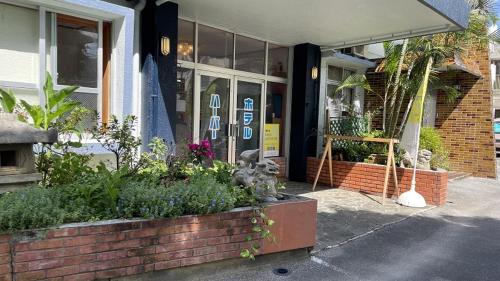 a store front of a building with plants in front of it at Hotel Harbor in Agena