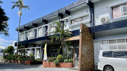 a white van parked in front of a building at Hotel Harbor in Agena